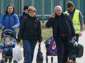 Des réfugiés ukrainiens marchent après avoir traversé la frontière entre l'Ukraine et la Pologne, au milieu de l'invasion russe de l'Ukraine, à Medyka, en Pologne, le 7 avril.