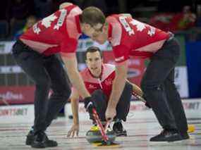 Lethbridge Ab, le 9 mars 2022, Tim Hortons Brier.Team Canada skip Brendan Bottcher d'Edmonton Ab livre sa pierre à son extrémité avant (LR) 2nd.Brad Thiessen et le plomb Karrick Martin (R) lors du tirage 15 contre l'équipe de l'Alberta.