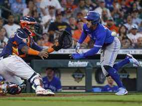 George Springer des Blue Jays plonge autour du receveur des Astros Martin Maldonado pour marquer un point lors de la quatrième manche hier à Houston.  Les Jays ont perdu en 10 manches, mais ont tout de même remporté le set de trois matchs 2-1.  Ils ont une fiche de 5-0-1 dans leurs six premières séries.