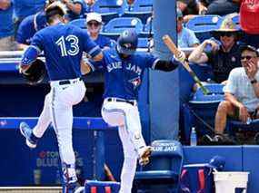 Le frappeur désigné des Blue Jays de Toronto Lourdes Gurriel Jr. (13) célèbre avec le voltigeur de base droit Cavan Biggio (8) après avoir frappé un coup de circuit en solo lors de la deuxième manche du match contre les Tigers de Detroit lors de l'entraînement printanier au TD Ballpark jeudi.