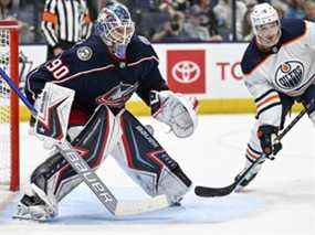 Le gardien de but des Blue Jackets de Columbus Elvis Merzlikins (90) suit la rondelle alors que le centre des Oilers d'Edmonton Derick Brassard (16) cherche à dévier un tir en deuxième période au Nationwide Arena le 25 avril 2022.