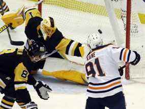 L'ailier gauche des Oilers d'Edmonton Evander Kane (91) marque un but contre le gardien de but des Penguins de Pittsburgh Casey DeSmith (1) alors que le défenseur des Penguins Brian Dumoulin (8) défend pendant la deuxième période au PPG Paints Arena.