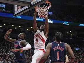 L'attaquant des Raptors de Toronto, Precious Achiuwa, lance le ballon contre l'attaquant des 76ers de Philadelphie Paul Reed et le garde James Harden au cours de la seconde moitié du troisième match du premier tour des séries éliminatoires de la NBA 2022 à la Scotiabank Arena.