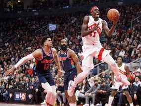 Pascal Siakam des Raptors, à droite, se dirige vers le filet alors que Tobias Harris des 76ers poursuit pendant la première moitié du quatrième match de la série de premier tour de la Conférence de l'Est à la Scotiabank Arena de Toronto, le samedi 23 avril 2022.