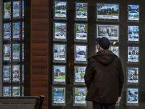 Une personne regarde des bulletins immobiliers à Toronto.