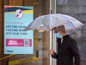 Un piéton portant un masque passe devant une affiche encourageant les Torontois à se faire vacciner contre la COVID-19 quand ce sera leur tour, au coin des rues Church et Queen, le jeudi 8 juillet 2021.