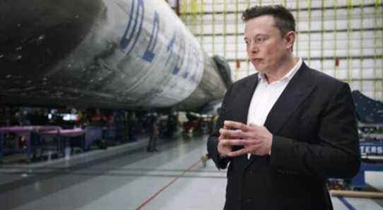 Man in suit stands in front of technology.