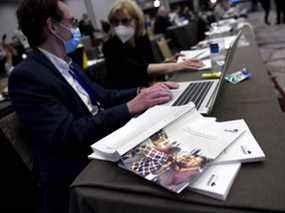 Des copies du budget fédéral de 2022 sont vues sur une table alors que des journalistes travaillent dans le huis clos des médias à Ottawa.