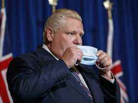 Le premier ministre de l'Ontario, Doug Ford, illustré ici en train de remettre son masque après une conférence de presse en décembre à Queen's Park à Toronto.