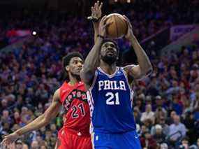 25 avril 2022 ;  Philadelphie, Pennsylvanie, États-Unis ;  Le centre des 76ers de Philadelphie, Joel Embiid, se déplace vers le panier devant l'attaquant des Raptors de Toronto, Thaddeus Young, au cours du quatrième quart du cinquième match du premier tour des éliminatoires de la NBA 2022 au Wells Fargo Center.