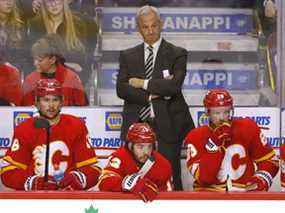 L'entraîneur-chef des Flames de Calgary Darryl Sutter derrière le banc du Scotiabank Saddledome à Calgary le jeudi 14 avril 2022.