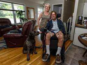 Ken Elliott, sa femme Linda Brooks et leur chien Roxy dans leur maison rénovée du lac Bonavista.  Elliott a été paralysé après avoir été abattu lors d'une invasion de domicile alors qu'il était en vacances à la Barbade.