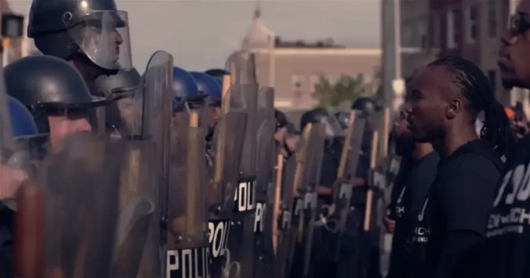 Protestors stand in front of police.