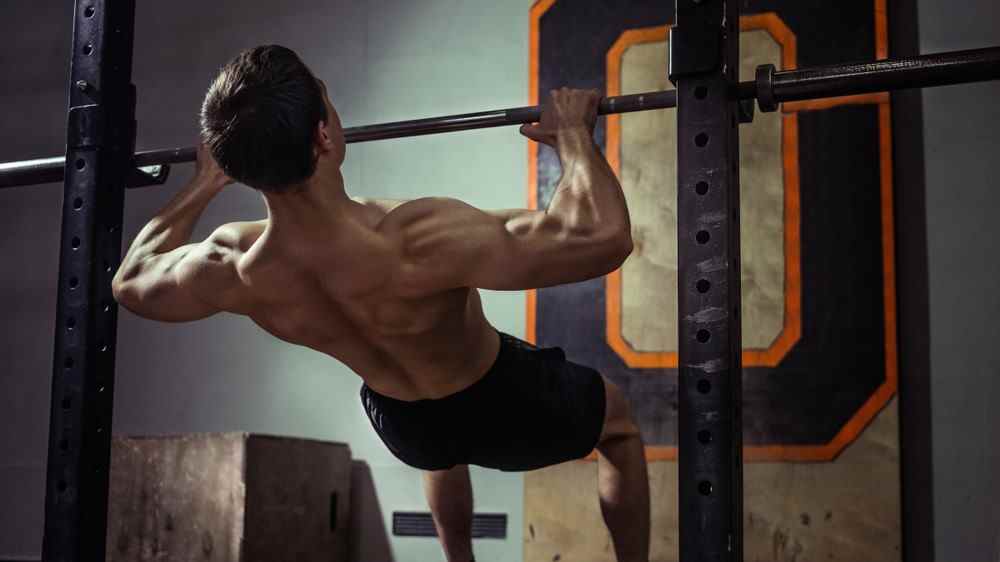 une photo d'un homme faisant un pull up inversé