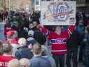 Louis Théberge, un fan de Guy Lafleur, affiche une pancarte en attendant le long de l'avenue des Canadiens-de-Montréal le dimanche 1er mai 2022, avant l'ouverture du Centre Bell, où le corps de Lafleur était exposé.