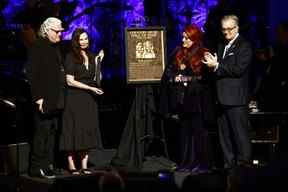 Wynonna Judd, deuxième à partir de la droite, se tient à côté de la plaque d'intronisation des Judds en tant que sœur Ashley Judd, à gauche, Ricky Skaggs, et MC Kyle Young, PDG du Country Music Hall of Fame & Museum, regardent pendant la cérémonie de remise des médailles au Pays Music Hall of Fame à Nashville, dimanche 1er mai 2022.