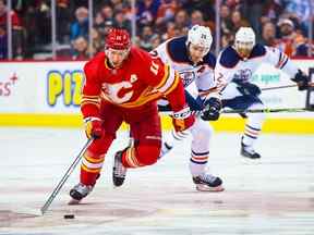 7 mars 2022 ;  Calgary, Alberta, CAN ;  Le centre des Flames de Calgary Mikael Backlund (11) patine avec la rondelle devant le centre des Oilers d'Edmonton Leon Draisaitl (29) au cours de la troisième période au Scotiabank Saddledome.