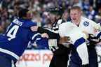 Les officiels séparent l'attaquant des Maple Leafs de Toronto Wayne Simmonds (24) et l'attaquant du Lightning de Tampa Bay Corey Perry (10) alors qu'ils se battent au cours de la troisième période, premier tour, match de hockey des séries éliminatoires de la Coupe Stanley de la LNH à Toronto, le lundi 2 mai 2022.  