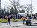 Un homme agite un drapeau canadien alors qu'un convoi Rolling Thunder arrive au centre commercial St-Laurent pour se rassembler avant leur route dans la ville d'Ottawa samedi matin.