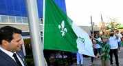 Le conseiller municipal Fred Francis, à gauche, assiste les étudiants Owen Drouillard, à droite, et Dalia El-Mais, derrière, lors de la cérémonie de lever du drapeau lors de la Journée franco-ontarienne à l'hôtel de ville le 25 septembre 2015. 