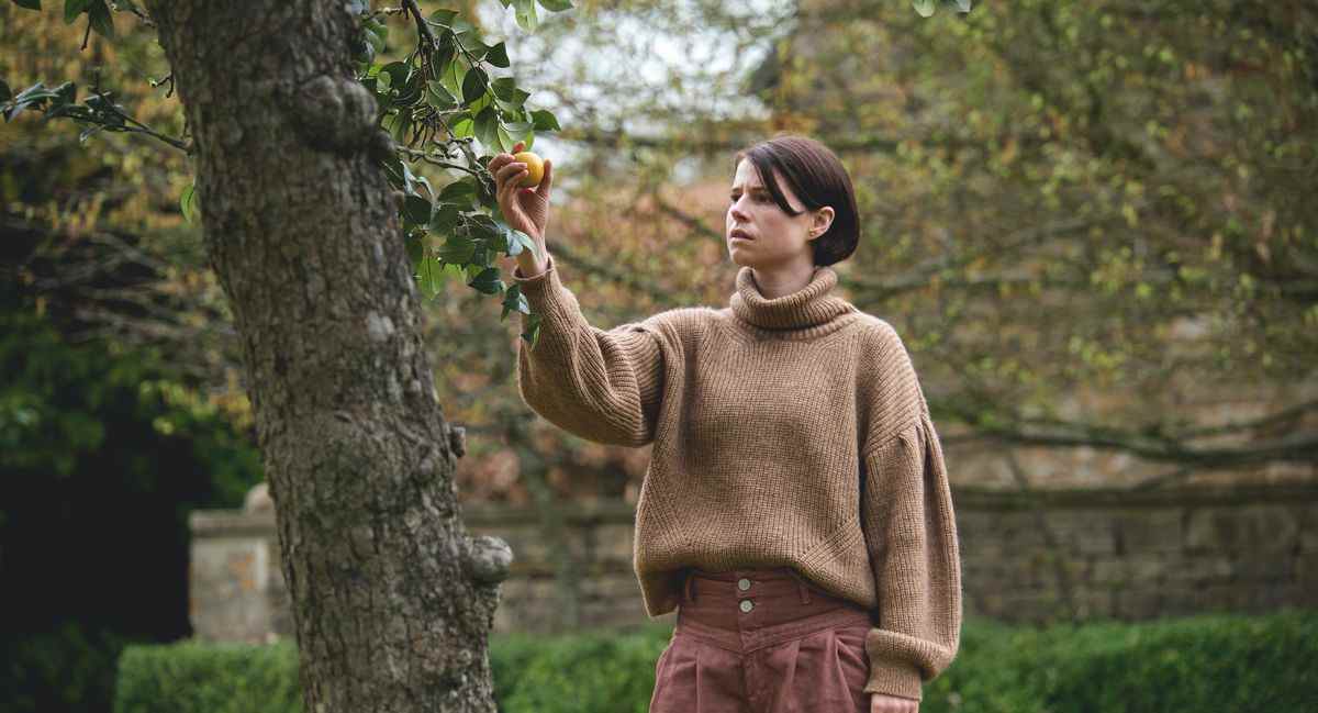 Jessie Buckley cueille une pomme hautement symbolique dans un arbre dans Men d'Alex Garland.