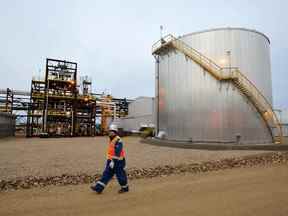 Un travailleur d'un champ pétrolifère passe devant l'installation de sables bitumineux de Statoil près de Conklin, en Alberta.