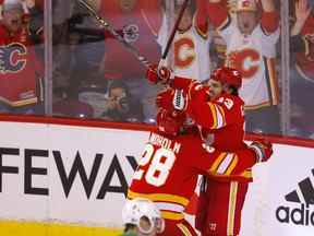 L'attaquant des Flames de Calgary Johnny Gaudreau est félicité par Elias Lindholm après son but vainqueur en prolongation pour vaincre les Stars de Dallas lors du septième match de leur série au Scotiabank Saddledome de Calgary le dimanche 15 mai 2022.