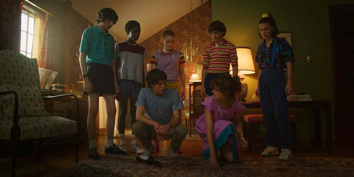 Mike, Lucas, Max, Jonathan, Will, El et Nancy dans un salon dans la saison 3 de Stranger Things