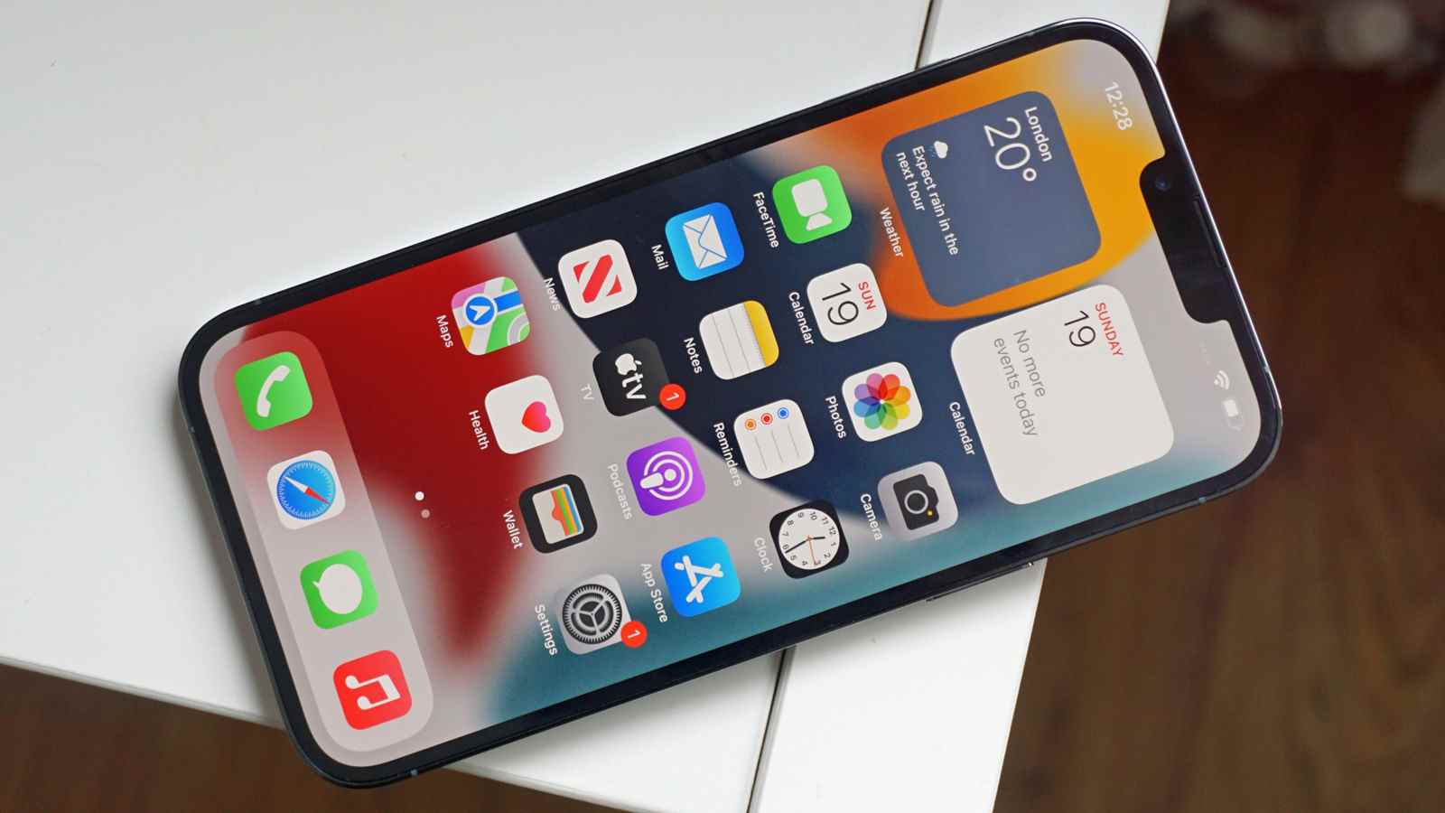 L'iPhone 13 Pro Max posé sur une table, face vers le haut, montrant l'écran d'accueil