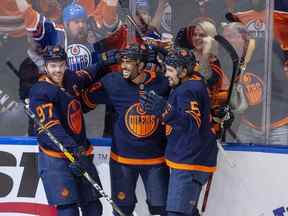 Les Oilers d'Edmonton Evander Kane (91) célèbrent son premier but avec ses coéquipiers Connor McDavid (97) et Cody Ceci (5) contre les Flames de Calgary lors de la deuxième période de hockey des séries éliminatoires de la LNH le dimanche 22 mai 2022 à Edmonton.