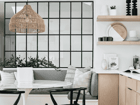 La banquette personnalisée a été équipée d'un espace de rangement pour les vêtements d'extérieur saisonniers de la famille.  Le mur de sécurité en verre a été ajouté car il y a un escalier au-delà.