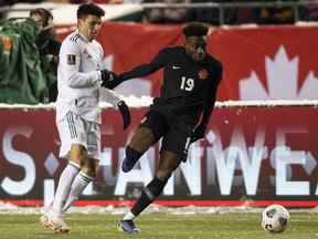 Alphonso Davies (19) du Canada et Julio Cesar Domingguez Juarez (3) du Mexique via pour le ballon lors des qualifications de la Coupe du monde à Edmonton, le mardi 16 novembre 2021.