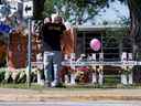 Des gens pleurent devant des croix commémoratives pour les victimes de la fusillade de masse qui a entraîné la mort de 19 enfants et de deux enseignants devant la Robb Elementary School à Uvalde, Texas, le 26 mai 2022.