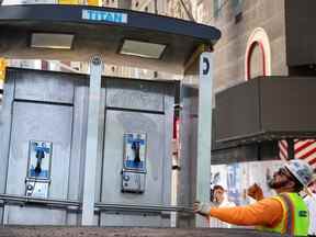 Un travailleur charge le dernier téléphone public sur un camion lors du déménagement près de Times Square à New York le 23 mai 2022.