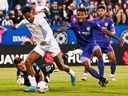 L'attaquant du CF Montréal Romell Quioto (30 ans) joue le ballon contre le gardien du FC Cincinnati Roman Celentano (18 ans) pour un but lors de la première mi-temps au Stade Saputo, le samedi 28 mai 2022, à Montréal.