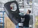 Un travailleur inspecte la porte d'un hélicoptère dans une usine de fabrication de Bell Helicopter Textron Canada à Mirabel, au Québec.