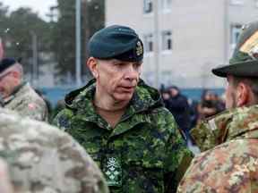 Le général Wayne Donald Eyre, chef d'état-major de la Défense canadienne, s'entretient avec des soldats dans une base militaire, au nord-est de Riga, en Lettonie, le 8 mars 2022.