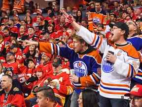 Les fans des Oilers d'Edmonton célèbrent après que Zach Hyman, numéro 18, a marqué contre les Flames de Calgary lors de la deuxième période du premier match de la deuxième ronde des séries éliminatoires de la Coupe Stanley 2022 au Scotiabank Saddledome le 18 mai 2022 à Calgary.