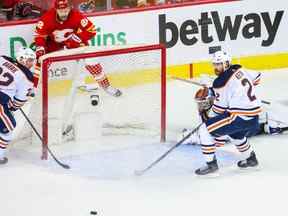 Le gardien de but des Oilers d'Edmonton Mikko Koskinen réagit alors que le centre des Flames de Calgary Trevor Lewis (22 ans) passe la rondelle au cours de la troisième période du premier match au Scotiabank Saddledome de Calgary le 18 mai 2022.