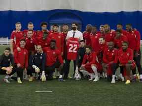 L'équipe nationale canadienne de soccer masculin pose pour une photo avec le premier ministre Justin Trudeau lors d'un entraînement au dôme de soccer d'Edmonton le lundi 15 novembre 2021 à Edmonton.