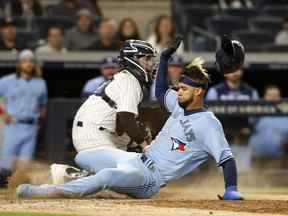 Lourdes Gurriel Jr. # 13 des Blue Jays de Toronto marque devant Jose Trevino # 39 des Yankees de New York lors de la huitième manche sur une mouche sacrificielle au Yankee Stadium le 10 mai 2022 à New York.