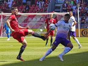 L'attaquant du Toronto FC Jesus Jimenez lance le ballon alors que le milieu de terrain du Orlando City SC Junior Urso défend au BMO Field.