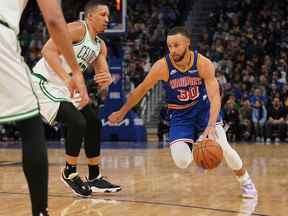 16 mars 2022 ;  San Francisco, Californie, États-Unis ;  Le garde des Golden State Warriors Stephen Curry (30 ans) dribble devant l'attaquant des Boston Celtics Grant Williams (12 ans) au deuxième quart au Chase Center.