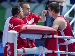 Brody Blair du Canada de New Glasgow, N.-É., s'entretient avec les entraîneurs Daniel Trepanier et Kevin Howard, à gauche, après avoir combattu Abdul Bangura de la Sierra Leone chez les 75 kg de boxe aux Jeux du Commonwealth à Glasgow, en Écosse, le samedi 26 juillet 2014.