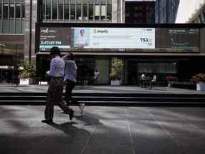 Les piétons passent devant la Bourse de Toronto dans le quartier financier de Toronto.