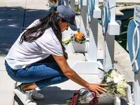 Meghan Markle, l'épouse du prince britannique Harry, dépose des fleurs alors qu'elle pleure sur un mémorial de fortune à l'extérieur du palais de justice du comté d'Uvalde à Uvalde, au Texas, le 26 mai.