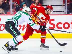 11 mai 2022 ;  Calgary, Alberta, CAN ;  Le centre des Flames de Calgary Dillon Dube et le défenseur des Stars de Dallas Joel Hanley se battent pour la rondelle au cours de la troisième période du cinquième match de la première ronde des séries éliminatoires de la Coupe Stanley 2022 au Scotiabank Saddledome.