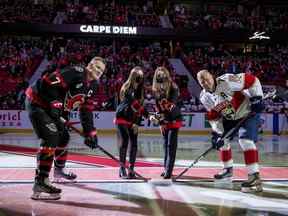 Anna, à gauche, et Olivia Melnyk effectuent une mise au jeu solennelle entre Brady Tkachuk des Sénateurs et Patric Hornqvist des Panthers avant un match le 28 avril.