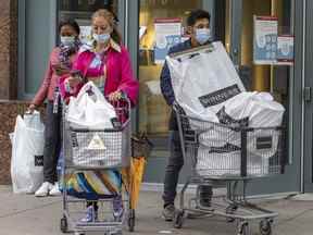 Les gens portent des masques à la sortie d'un centre commercial du centre-ville de Montréal le mercredi 4 mai 2022. Les responsables de la santé publique ont annoncé la fin des mandats de masque dans la plupart des situations à compter du 14 mai.