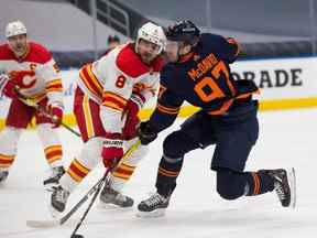 Connor McDavid (97) des Oilers d'Edmonton marque sur les Flames de Calgary alors qu'il passe la rondelle devant Christopher Tanev